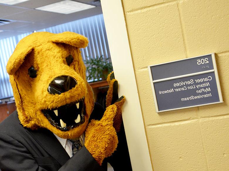 Nittany Lion mascot pointing at a career services sign